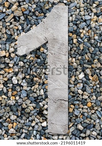 Number one with concrete texture, on stones background