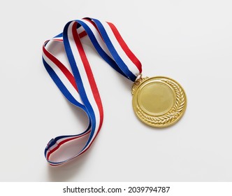 Number one gold medal. Champion first place winner athlete. Prize in sport trophy award and red and blue ribbon isolated on white background. Blank space and laurel wreath, template