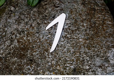 Number one on the dark stone. Sign on the asphalt.