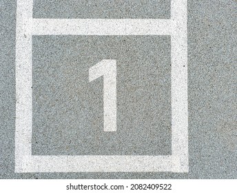 Number one painted on soft rubber surface. Jumping hopscotch game with numbers. Safety outdoor playground. Number 1.