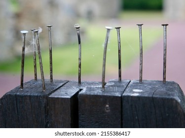 A number of rusty old nails hammered into the gatepost at the entrance to the Chateau, Chateau de Montfort, Remilly-les-Marais, Manche, Normandy, France on Thursday, 12th, May, 2022