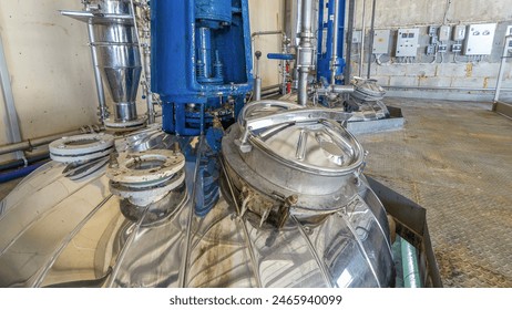 A number of steel tanks for mixing liquids timelapse hyperlapse. Stainless steel, industry. Operator near control panel - Powered by Shutterstock