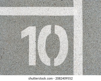 Number ten painted on soft rubber surface. The tenth place, Jumping hopscotch game with numbers. Safety outdoor playground