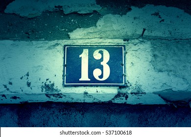 Number thirteen on a wall, detail of a number of information in a house