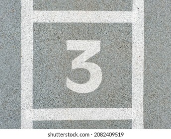 Number three painted on soft rubber surface. Jumping hopscotch game with numbers. The third possition. Safety outdoor playground