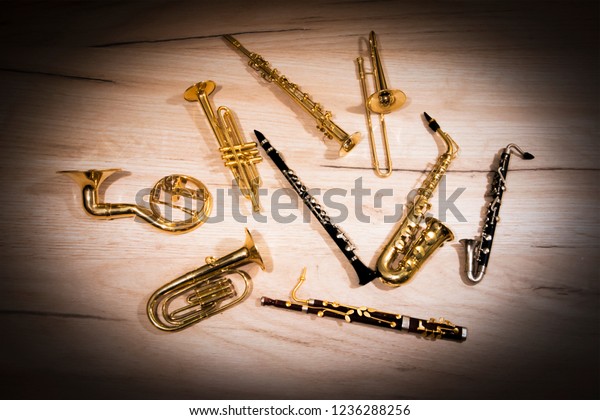 A number of toy wind instruments  lying on a\
wooden board, dark vignette