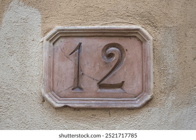 Number twelve carved into a terracotta plate - Powered by Shutterstock