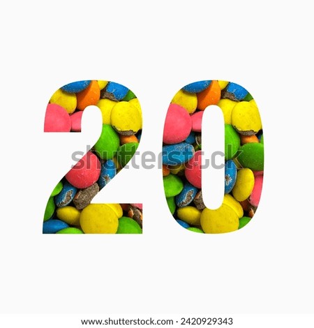 Number twenty of colourful candies and paper cut in shape of twentieth digit isolated on white. Rainbow typeface