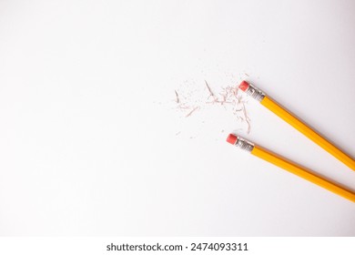 number two pencils with eraser ends against a white background with eraser shavings 