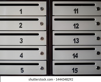 Numbered mailboxes. Boxes for paper mail. Grey mailboxes