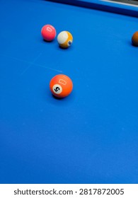 Numbered Pool Balls Resting on a Blue Felt Billiards Table with Selective Focus and Copy Space