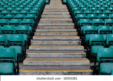 Numbered steps in a sports stadium in between the green plastic seating. - Powered by Shutterstock