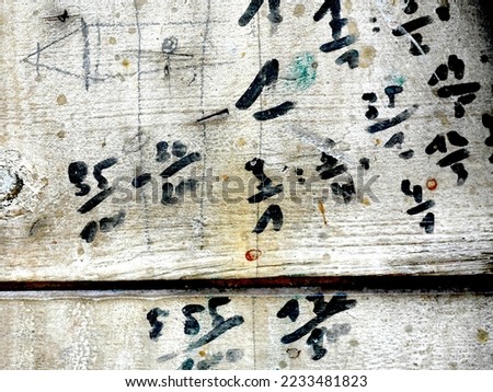 numbers and calculations written on a wooden wall