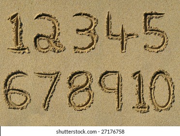 Numbers one to ten written on a sandy beach.