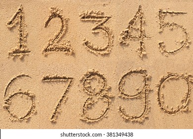 Numbers one to ten written on a sandy beach. 