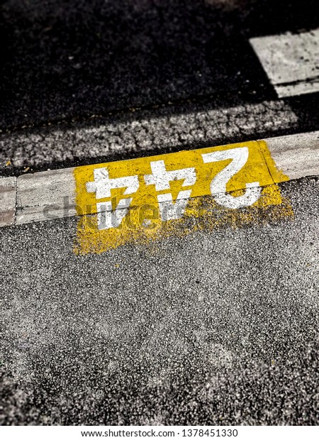 Numbers painted on the pavement to indicate the\
position of a parking\
space
