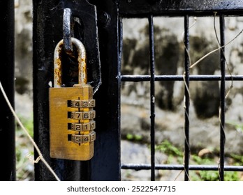 The numeric code padlock locks the iron gate door.