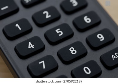 Numerical Input: High-Angle Close-up of Remote Control Keypad for Data and Channel Entry.