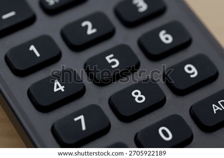 Numerical Input: High-Angle Close-up of Remote Control Keypad for Data and Channel Entry.