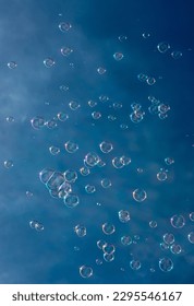 Numerous Colorful Soap Bubbles Float In Mid-Air In Front Of Blue Sky
