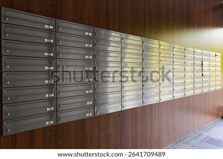 Numerous metal mailboxes are securely installed along a wall in a residential building corridor, offering a private space for mail delivery and correspondence collection.