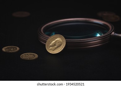 Numismatics. Old collectible coins made of gold on a wooden table.  Dark background.