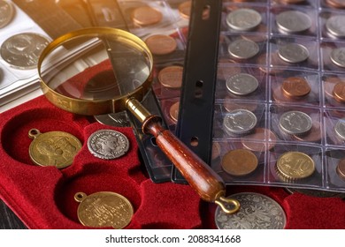 Numismatics. Old collectible coins made of silver on a wooden table.Coins in the album.Collection of old coins. Magnifying glass - Shutterstock ID 2088341668
