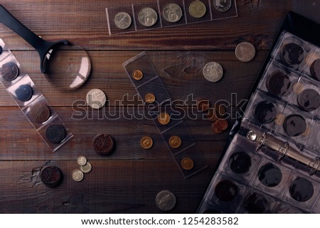 Numismatics. Old collectible coins made of silver, gold and copper on a wooden table. Top view.