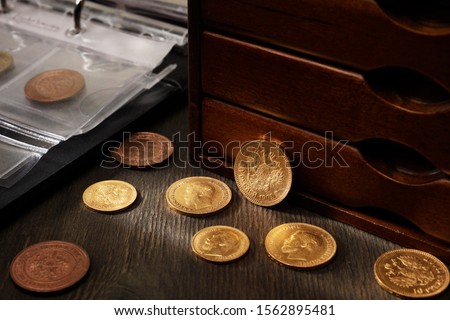 Numismatics. Old collectible coins made of silver, gold and copper on a wooden table. 