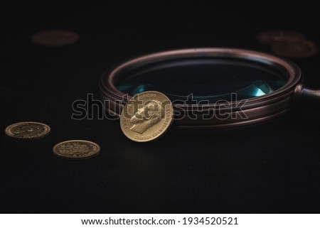 Numismatics. Old collectible coins made of gold on a wooden table.  Dark background.