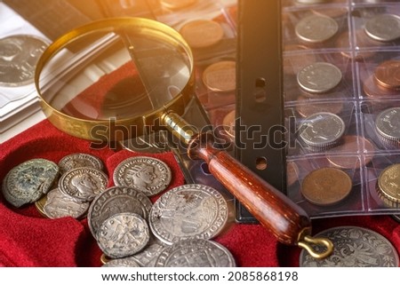 Numismatics. Old collectible coins made of silver on a wooden table.Coins in the album.Collection of old coins. Magnifying glass ストックフォト © 