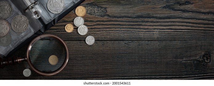 Numismatics. Old collectible coins on a wooden table.  Dark background. Banner.  Copy space of your text.