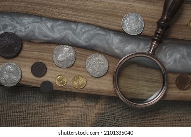 Numismatics. Old collectible coins on a wooden table. Dark background. Top view.