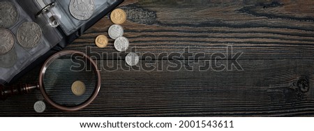 Numismatics. Old collectible coins on a wooden table.  Dark background. Banner.  Copy space of your text.