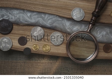 Numismatics. Old collectible coins on a wooden table. Dark background. Top view.