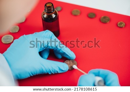 Numismatist Cleaning Ancient Coins Collection