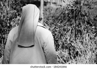 A Nun In Grey Robe In The Forest. A Game Of Light And Shadow. Religion And Nature. Meditation Background. Harmony, God In Nature Idea. Aged Photo. Black And White.