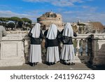 Nuns on the Ponte Vittorio Emanuele II look at Rome and Castel Angelo