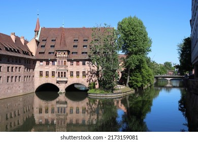 Nuremberg Landmark In Germany. Holy Spirit Hospital (Heilig-Geist-Spital) On River Pegnitz. Medieval Landmark.