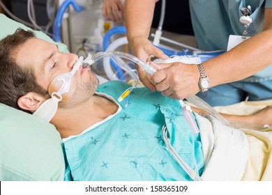 Nurse adjusting endotracheal tube in patient's mouth at hospital