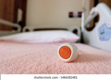Nurse alarm button on a hospital bed where patients can alert nurses for help or call attention in an emergency by pressing the red call button.