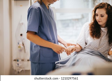 Nurse Applying An IV Drip To A Patient