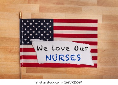 Nurse Appreciation Sign We Love Our Nurses Written On A Torn Sheet Of Paper Laying On An American Flag Flat Lay 