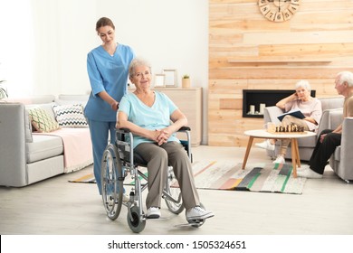 Nurse assisting elderly woman in wheelchair at retirement home. Space for text - Shutterstock ID 1505324651