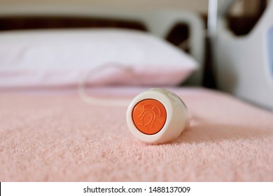 Nurse call button on a hospital bed for patients to request nurses' assistance or alert nursing staff of any emergency by the press of a button, closeup view.