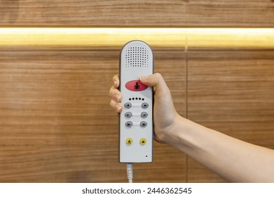 Nurse call button in patient room in modern hospital. Hand pushing nurse call button. patient press red emergency button to calling nurse for help in hospital