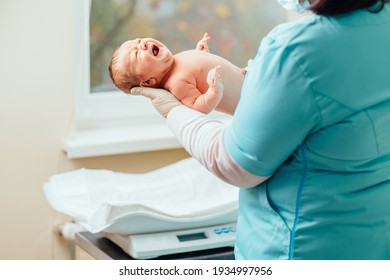 Krankenschwester beruhigt Neugeborene in der Postpartum-Station. Medizinisches Personal, das sich um einen Säugling kümmert.