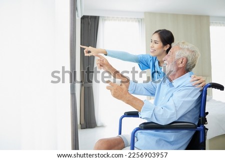 Similar – Caregiver looking through the window with elderly patient in wheelchair