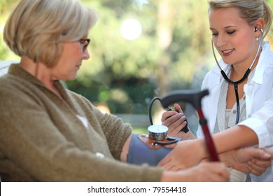 Nurse Is Checking Old Woman's Blood Pressure