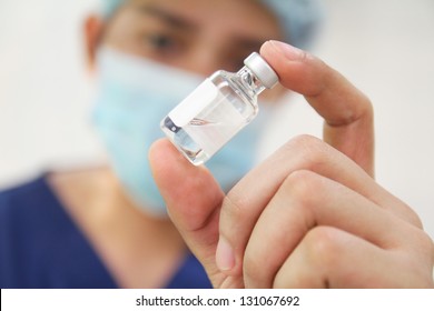 Nurse checking a vial of medicine.